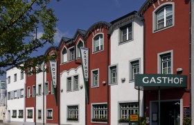 Au&szlig;enansicht des Restaurant-Hotels Wallner mit roter und wei&szlig;er Fassade.