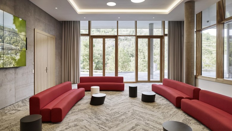 Moderner Tagungsraum mit roten Sofas und gro&szlig;en Fenstern im Steigenberger Krems.