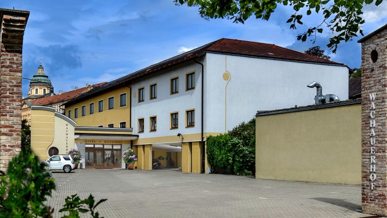 Au&szlig;enansicht des Wachauerhofs in Melk mit Parkplatz und Geb&auml;udefassade.