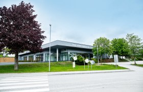 Franz Himmer Kongress- und Veranstaltungszentrum mit B&auml;umen und Gehweg im Vordergrund.